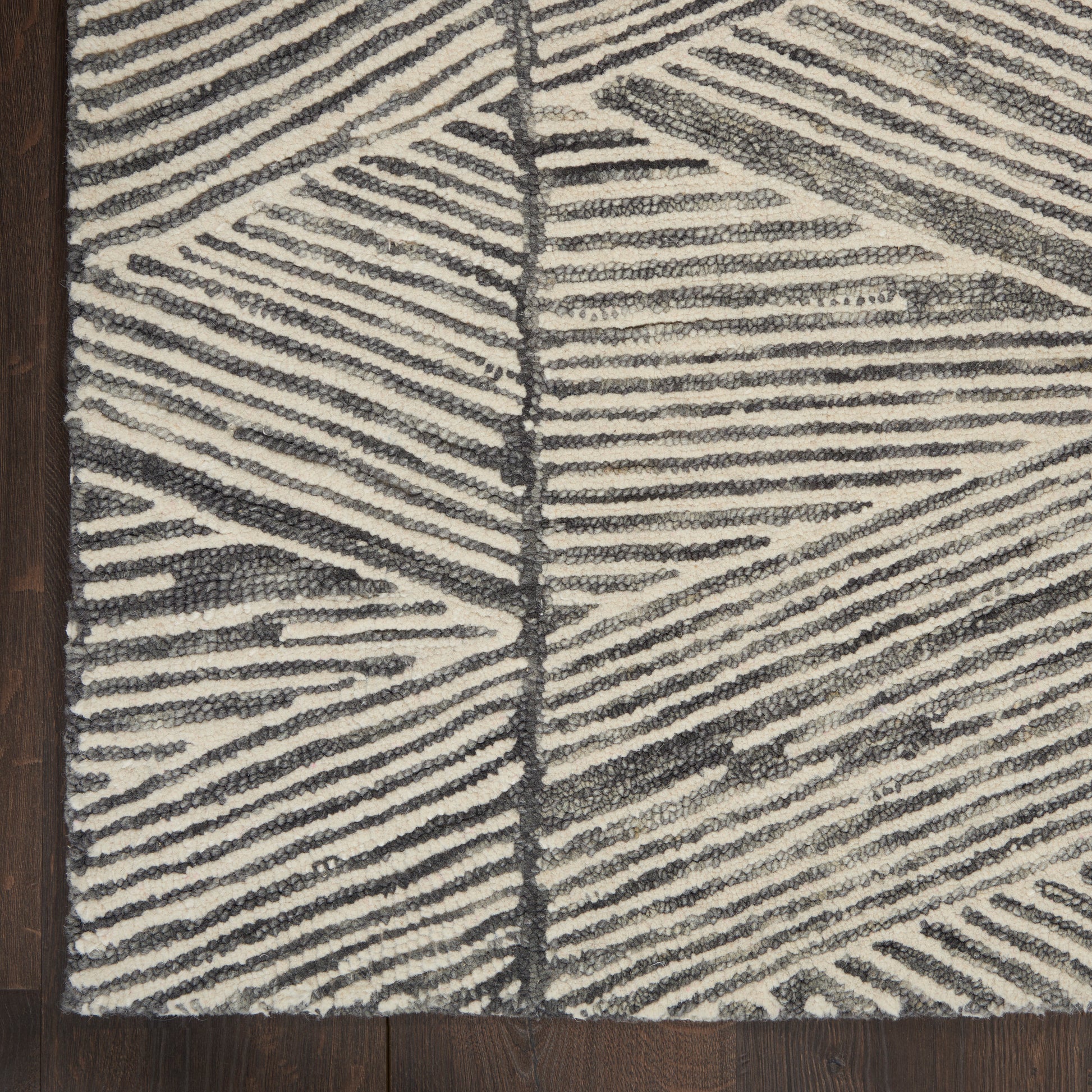 Rectangular ivory and charcoal rug with bold linear geometric pattern; plush textured pile on dark wood floor