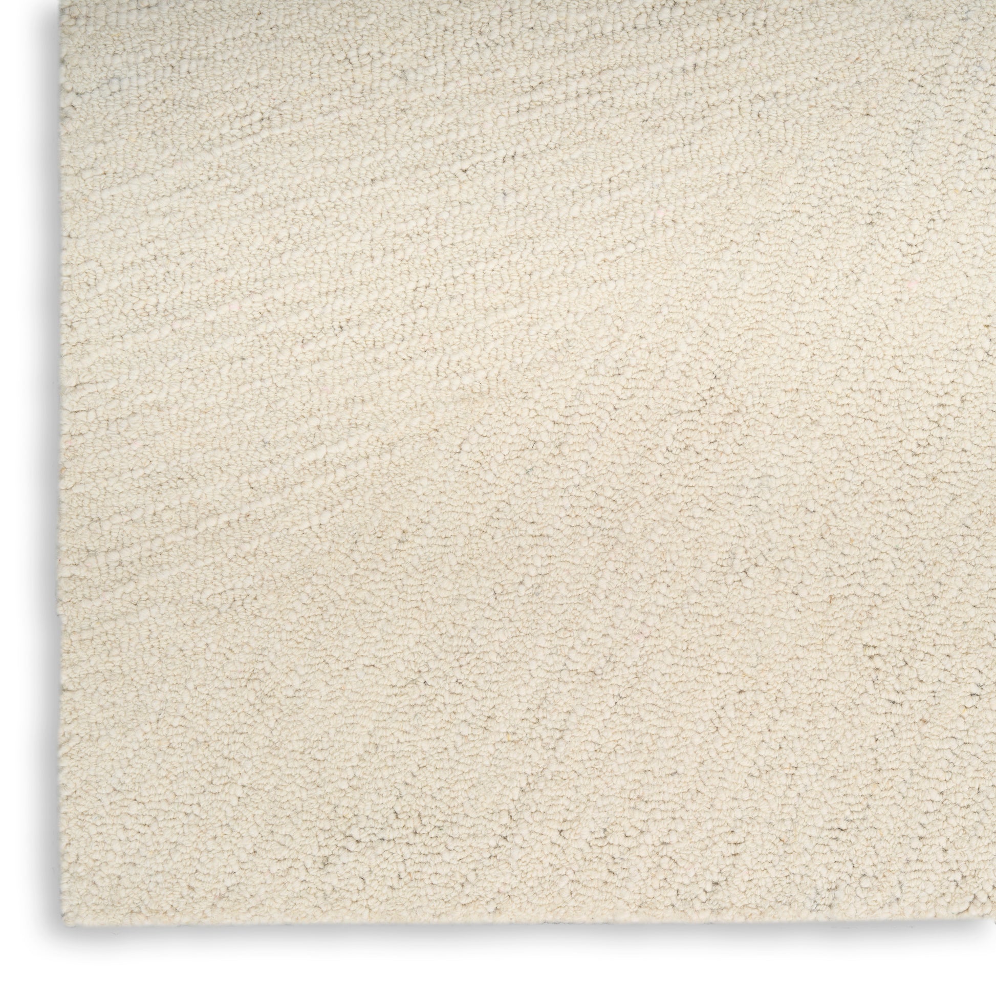 Cream beige plush rug with dense loop pile and subtle swirled texture, close-up view.