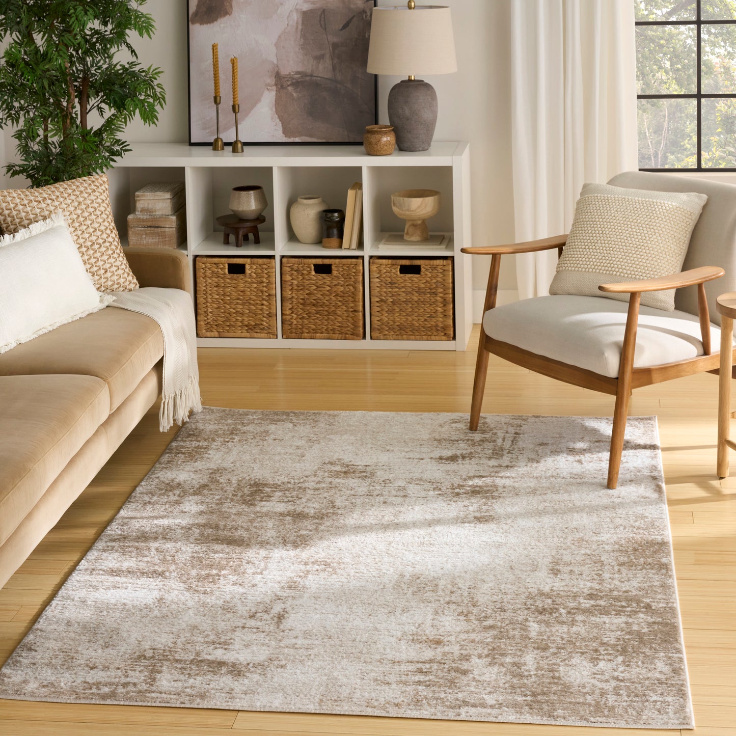 Rectangular plush area rug in taupe-beige with a distressed cream pattern for a cozy living room.