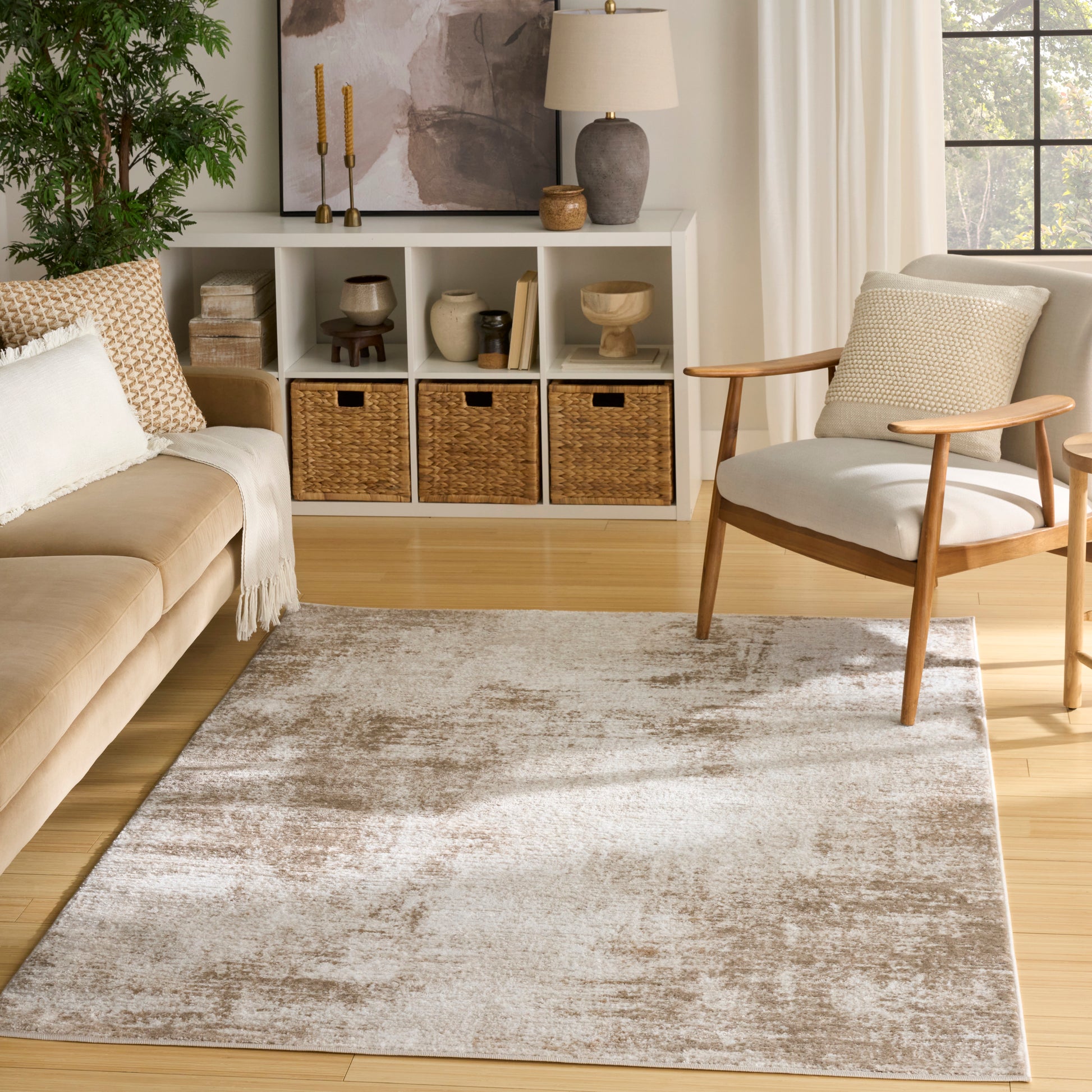 Rectangular plush area rug in taupe-beige with a distressed cream pattern for a cozy living room.
