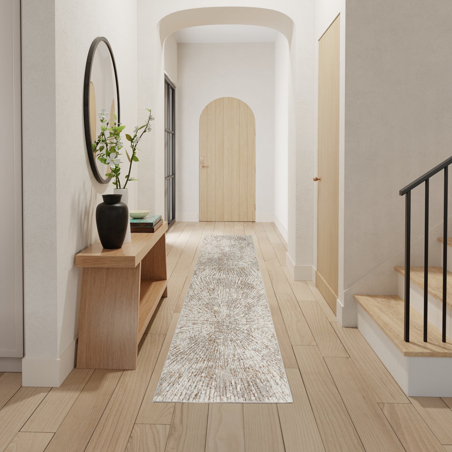 Minimalist hallway: light wood floors, beige runner, round wall mirror, wooden console with vase, arched door, staircase.