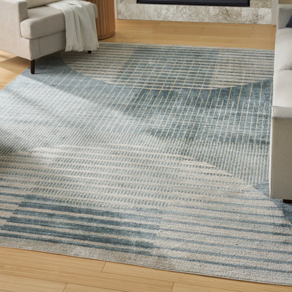 Blue-gray striped area rug with a modern geometric pattern on light hardwood floor in a contemporary living room.