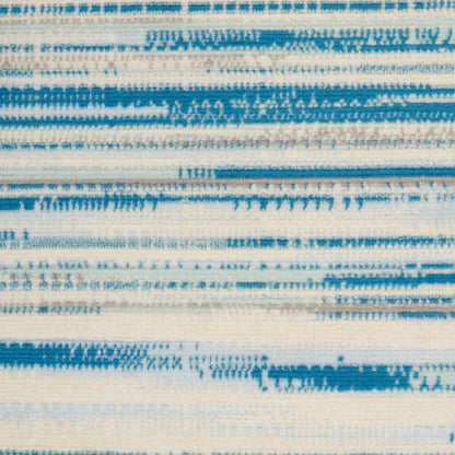 Blue & white striped woven rug with faded brushstroke patterns across a cream background