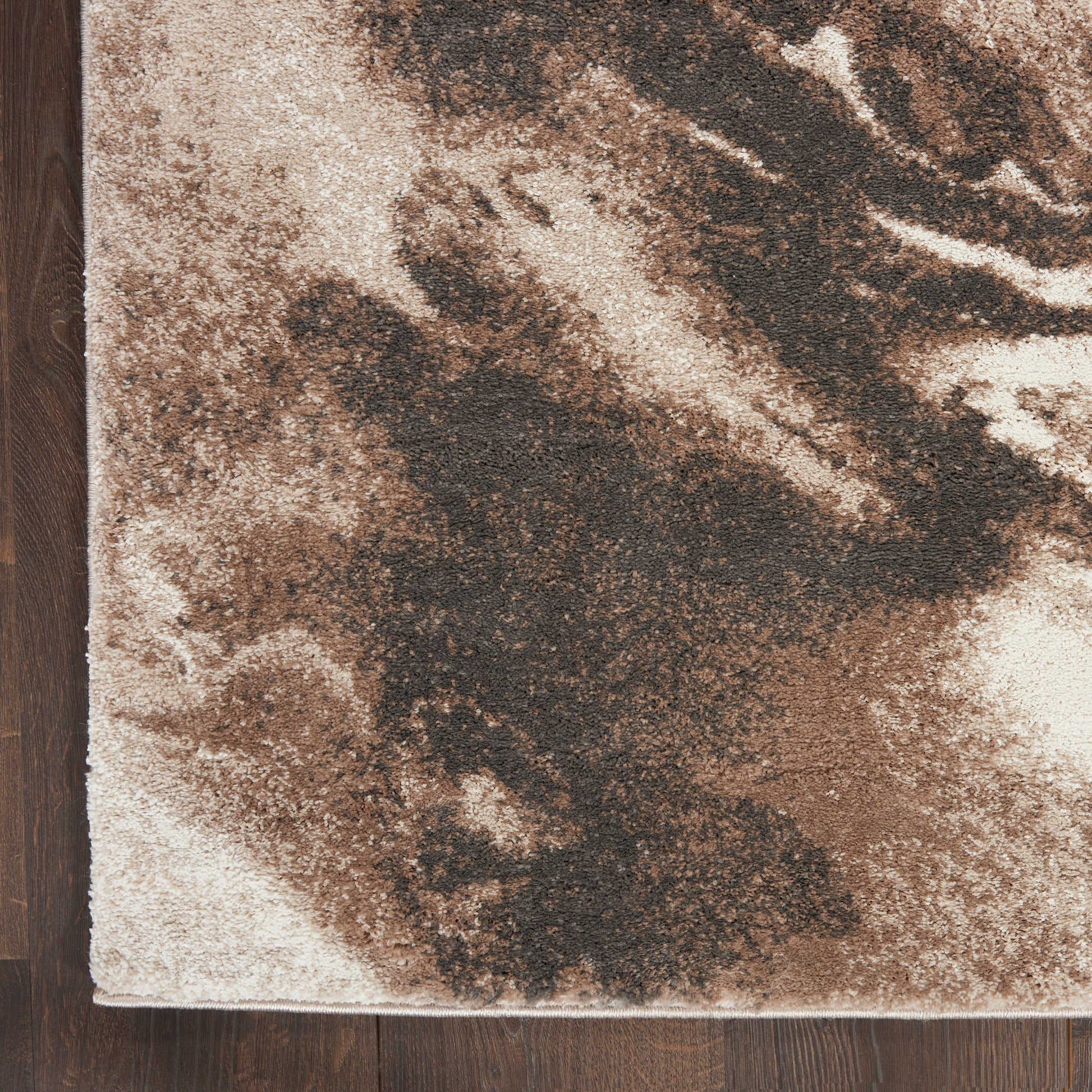 Abstract brown-tan rug runner with beige background on dark wood floor; plush shag style, rectangular, modern decor.