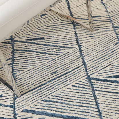 Cream rug with navy geometric chevron lines under chrome-leg chair.