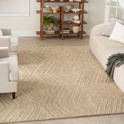 Beige jute rug with a subtle chevron pattern anchors a neutral living room with light gray sofas and a wooden open shelf.