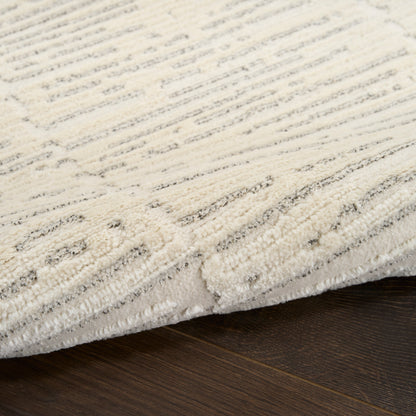 Cream textured area rug with subtle gray geometric pattern and plush pile on dark hardwood floor.