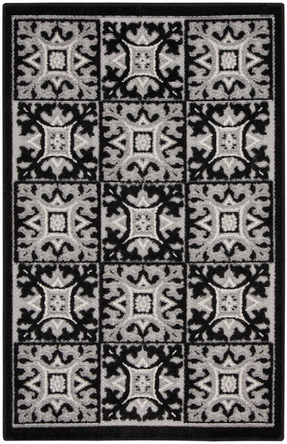 Black and gray patterned rug with a grid of ornate square tiles and a solid border.