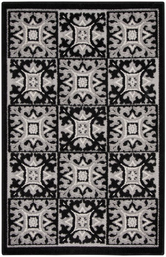 Black and gray patterned rug with a grid of ornate square tiles and a solid border.