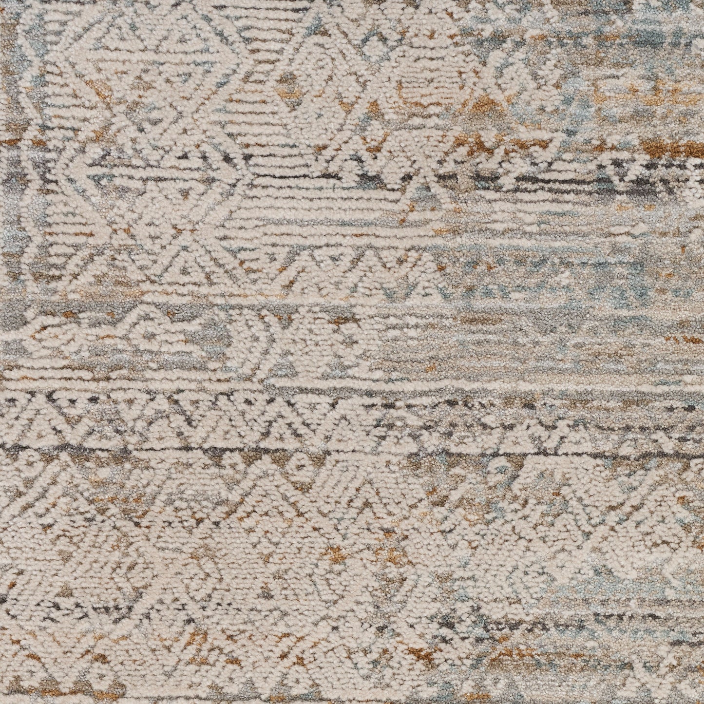Distressed geometric area rug in cream, beige, blue and taupe with tribal motifs and soft texture.