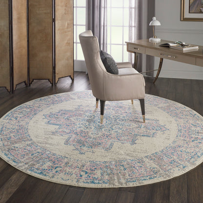 Beige curved-arm accent chair with dark tapered legs on a round pastel rug in a cozy home office.