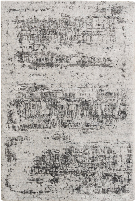 Light gray distressed area rug with irregular charcoal patches, modern style & soft textured pile.