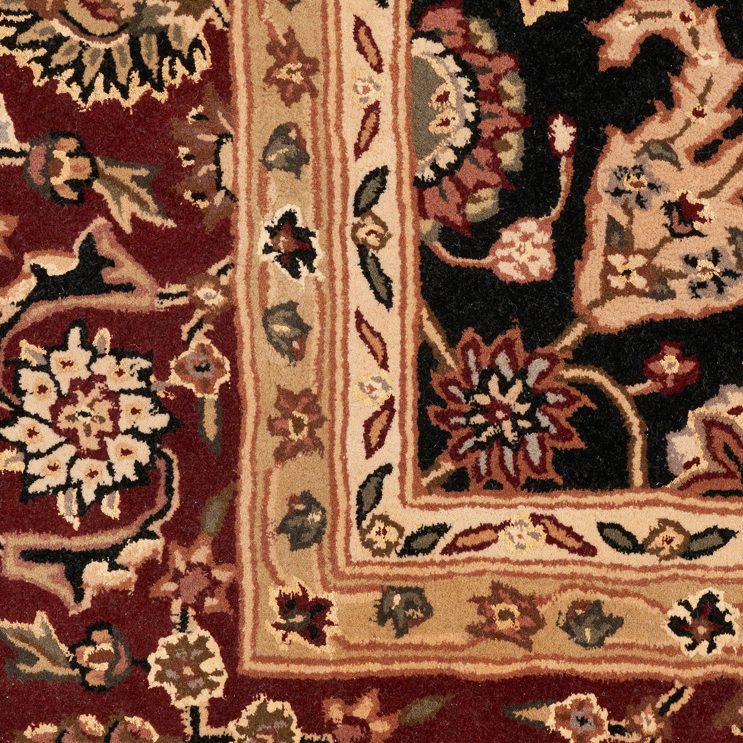 Persian-style area rug with deep red field, ornate beige/gold border, and colorful floral motifs.