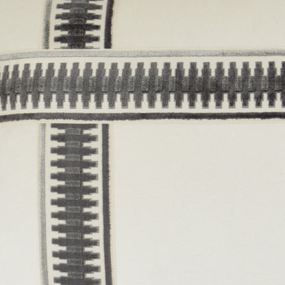 Close-up of black metal zipper teeth on grey fabric of a 24" x 24" pillow, showing cross seam and textured textile detail.