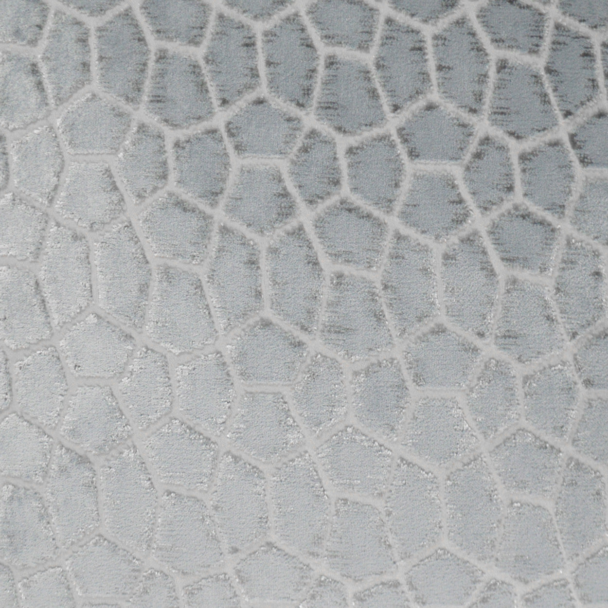 Light grey fabric with white raised irregular polygon mosaic pattern; giraffe-like textured upholstery surface.