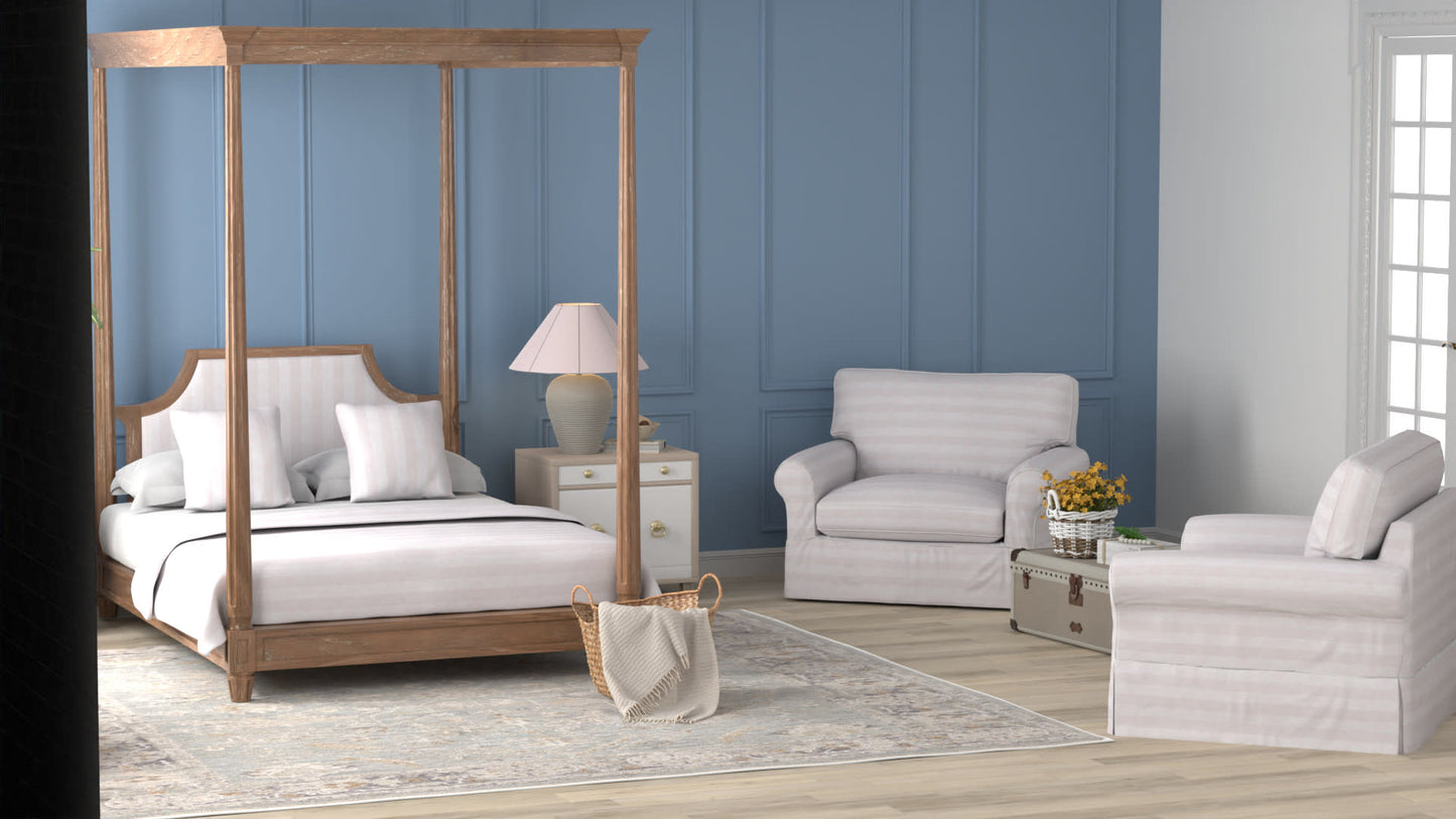Wood canopy bed with white bedding against blue paneled wall, beige nightstands & lamps, and light cream seating area.