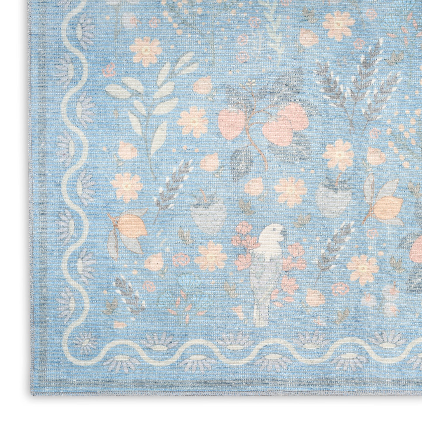 Pastel blue woven rug featuring pink and cream florals and a white scalloped border with a small bird motif.
