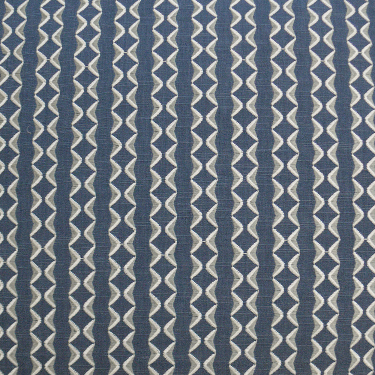 Navy blue notch pillow, 24" x 24", with white geometric diamond motifs in vertical stripes; woven textile.