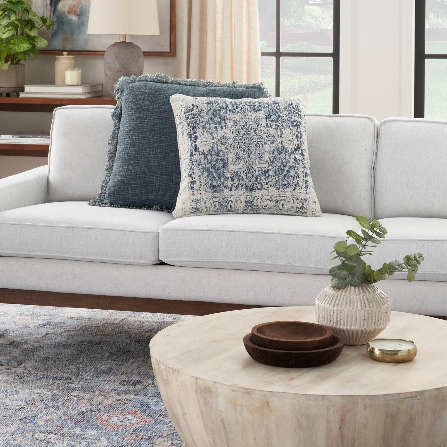 Light gray rug with ivory and navy farmhouse pattern on the floor.