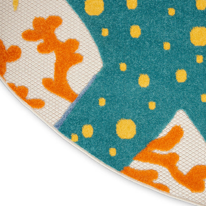 Round teal rug with yellow dots and orange coral motifs on white curved panels; woven textile.