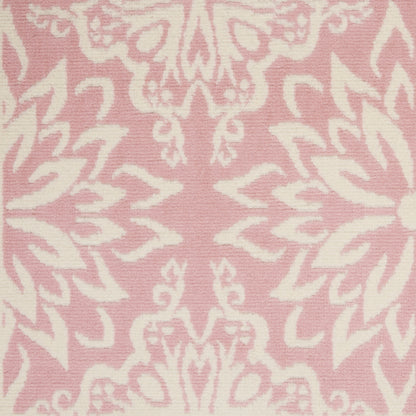 Pink damask rug with white ornate floral motifs in a repeating decorative pattern.
