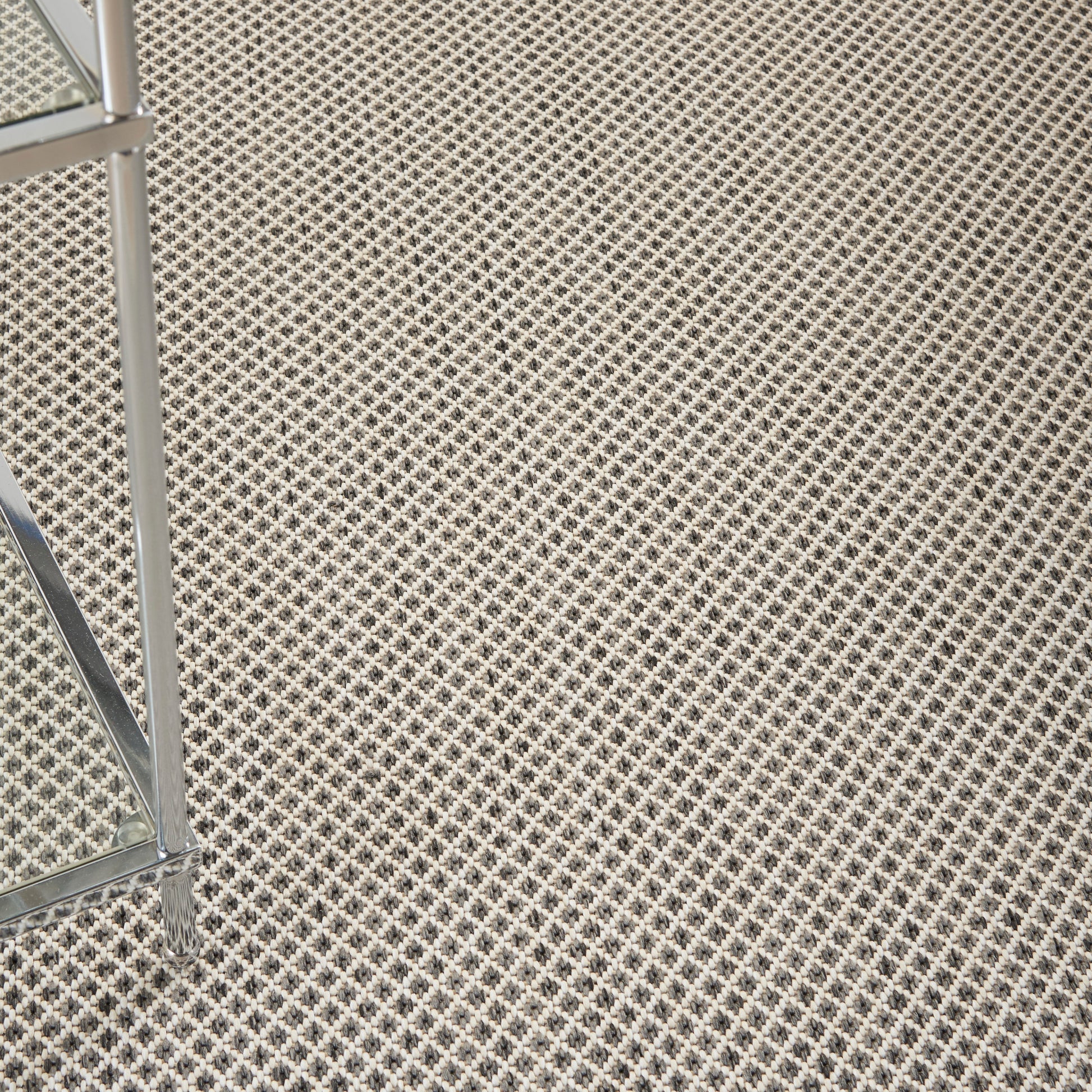 Beige modern rug on a black-and-white lattice floor; 4' x 6'.