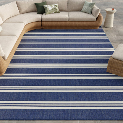 Blue striped woven area rug under a beige curved sectional sofa in a modern living room.