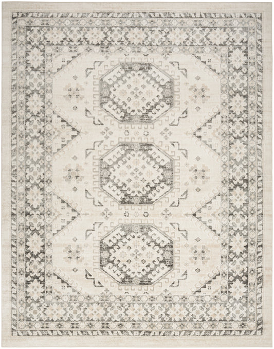 Neutral-toned area rug with three stacked hexagonal medallions, ivory and charcoal pattern, ornate floral border.