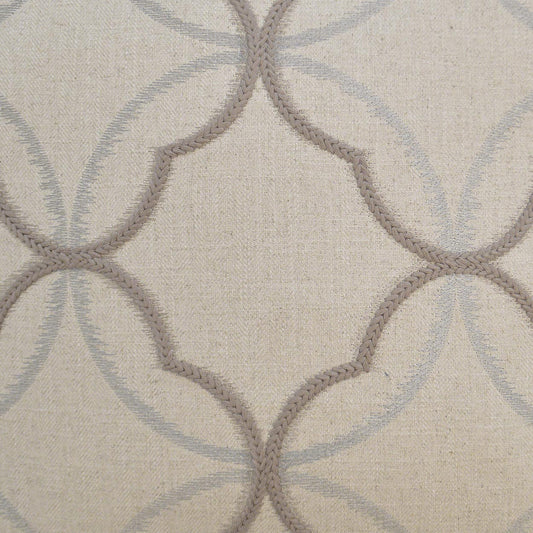 Beige woven fabric with taupe rope-outline quatrefoil motifs and pale blue circular arches.