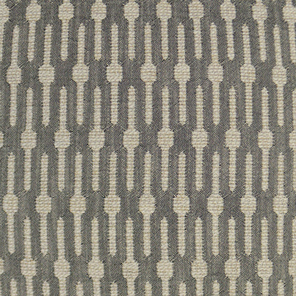 Cream elongated oval motif in vertical rows on charcoal gray woven fabric; geometric retro pattern.