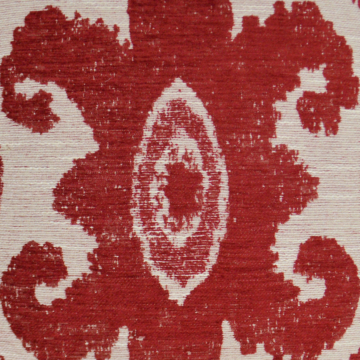 Red damask jacquard fabric with ivory central oval motif and scrolling patterns on beige background.