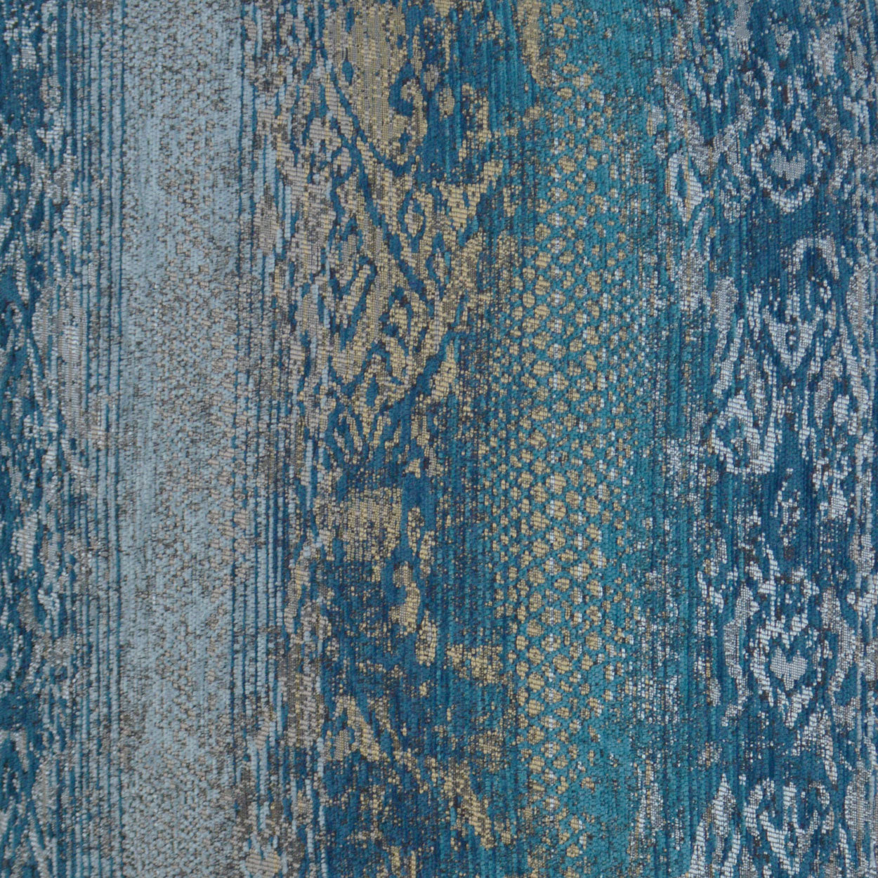 Blue teal patchwork fabric with damask and geometric patterns in gold/beige; woven upholstery/rug textile.