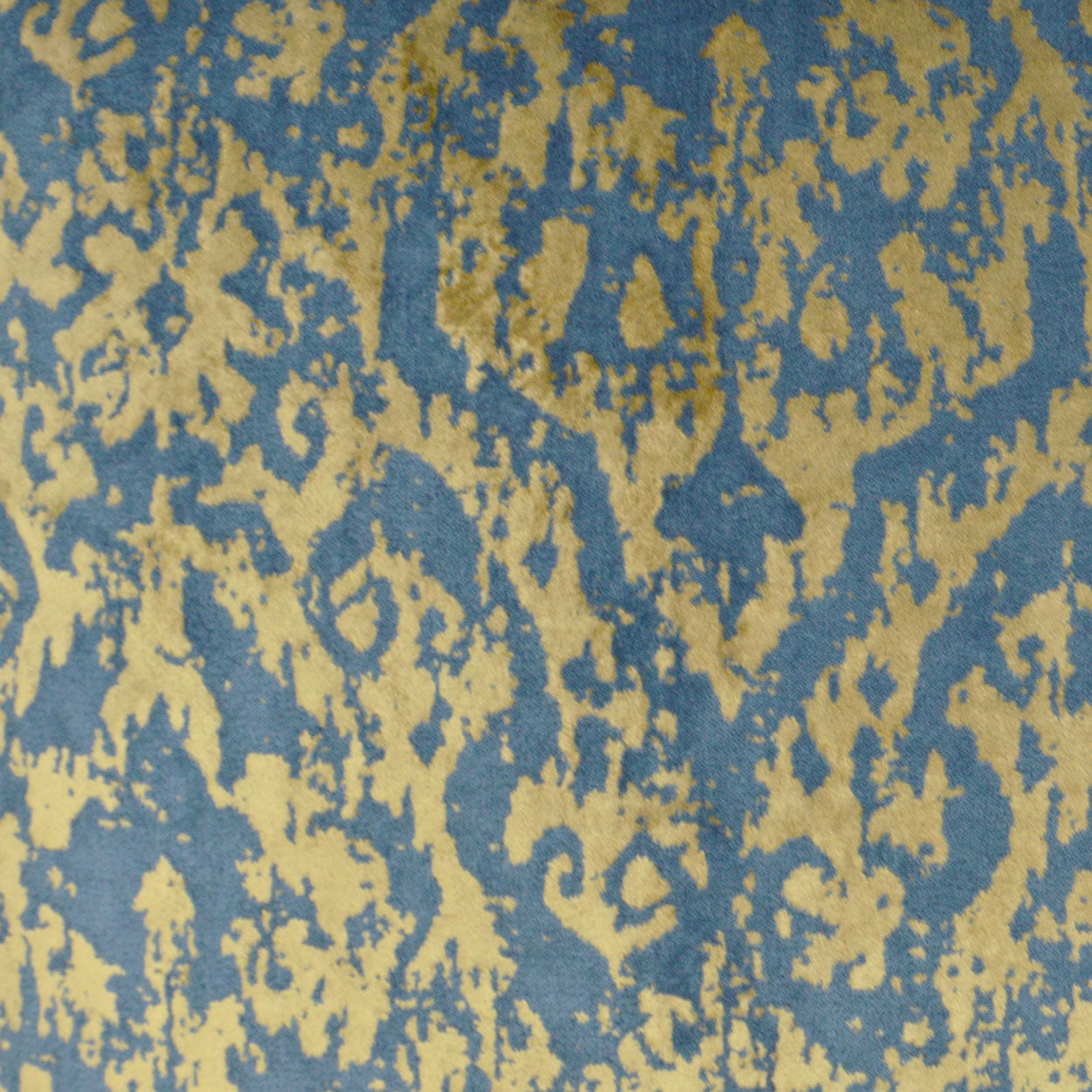 Blue fabric with irregular gold mottled pattern, ikat-style textile.
