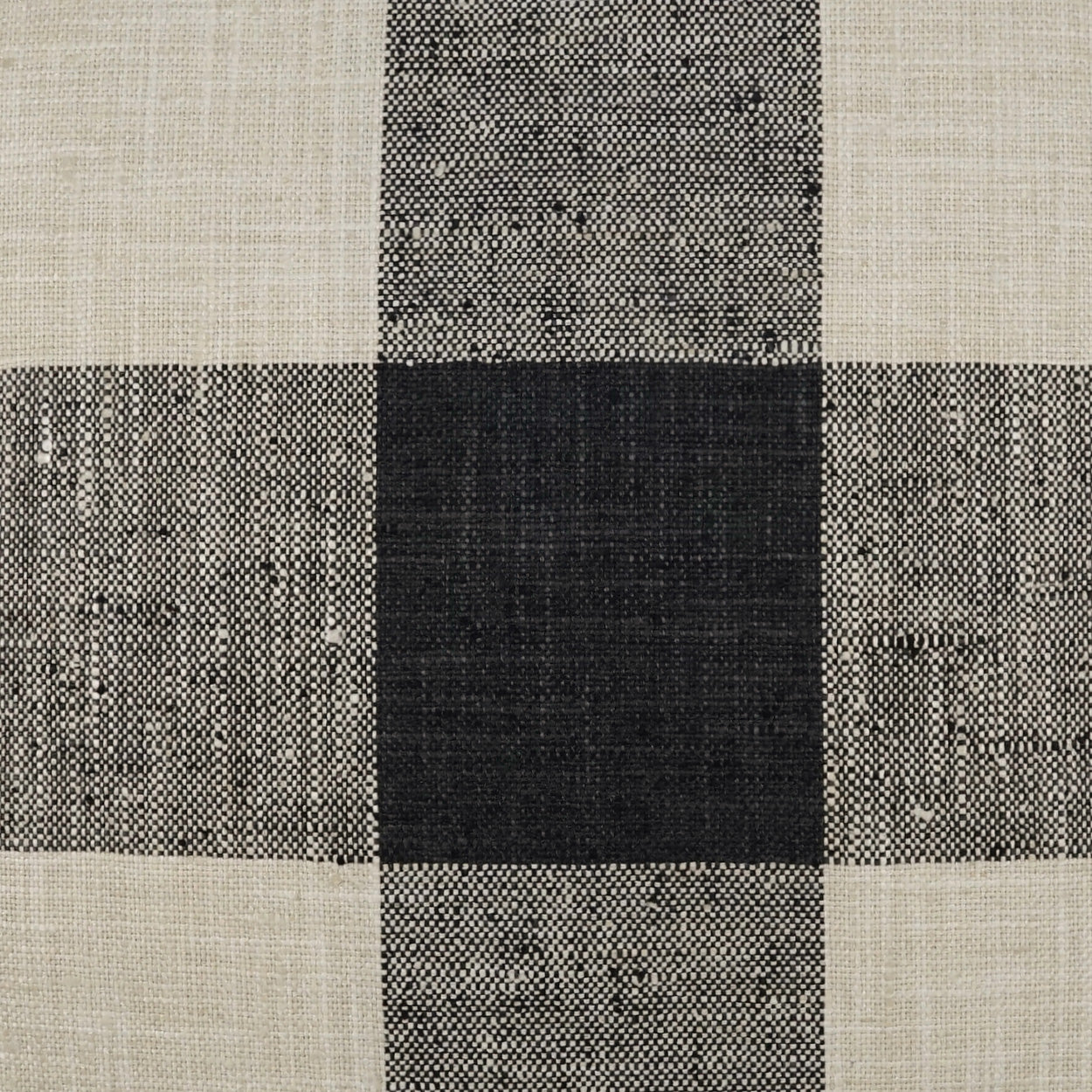 Pillow with a charcoal plaid check pattern on woven fabric.