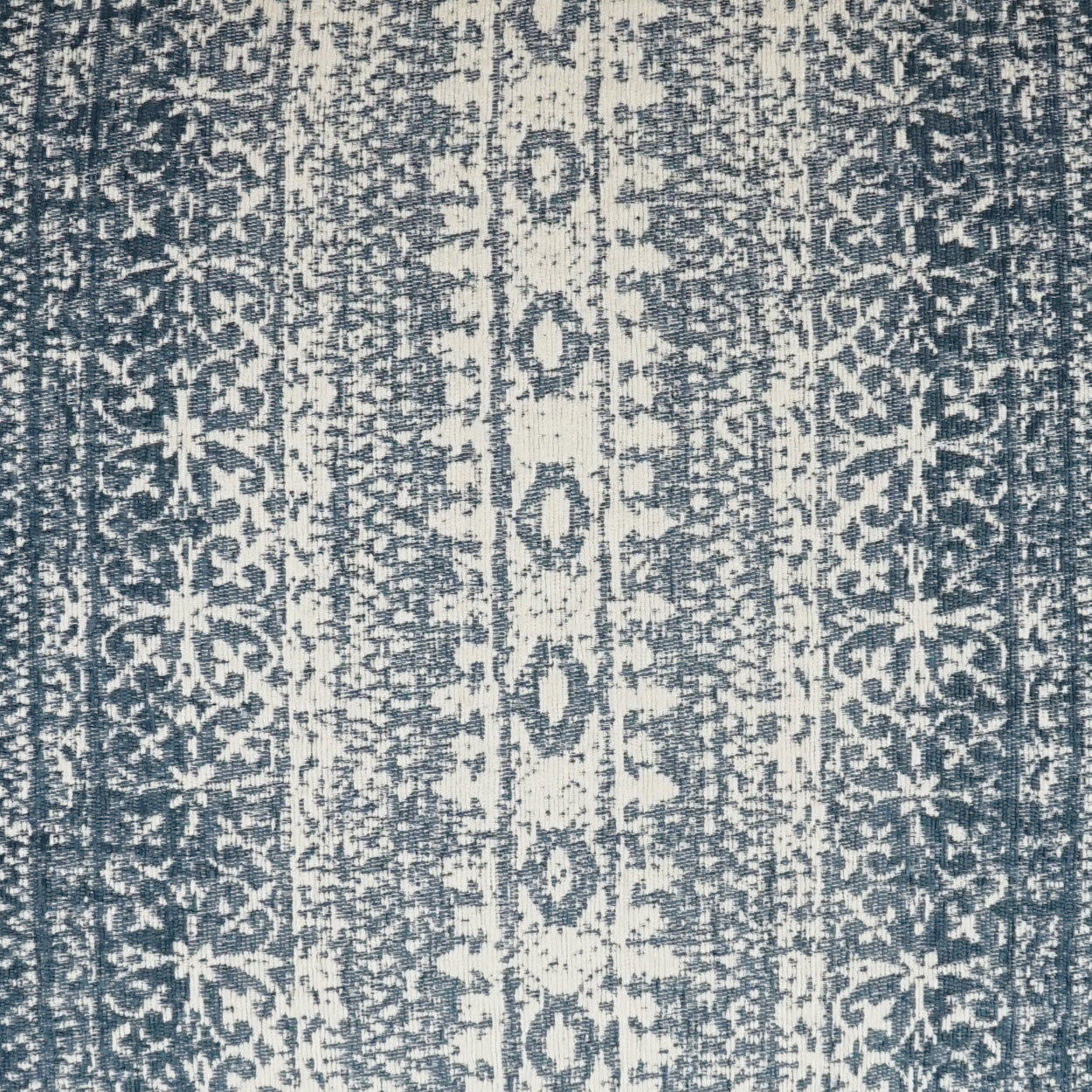 Blue and ivory striped textile rug with vertical geometric medallion motifs; woven floor decor.