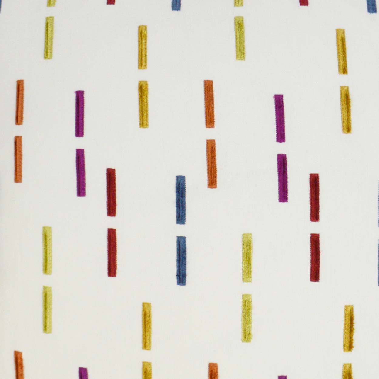 White fabric with randomly spaced vertical color dashes in yellow, orange, red, purple and blue.