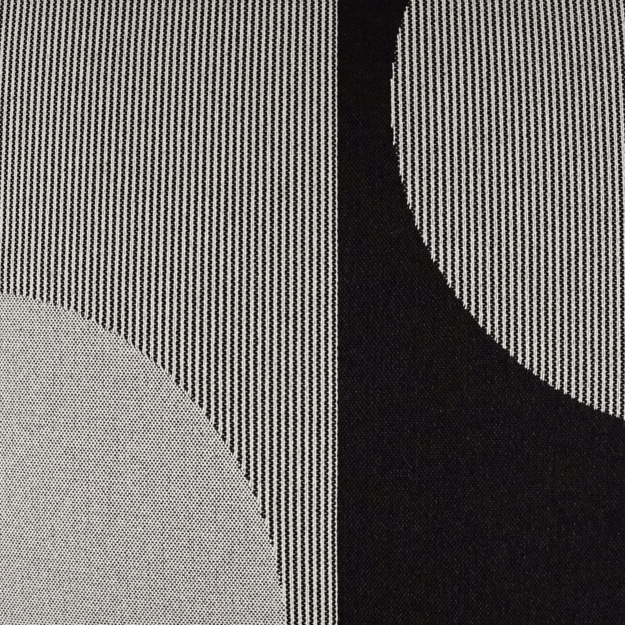 Close-up fabric with black-and-white pinstripes, gray curved patch on left and black curved panel on the right.