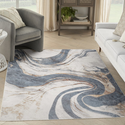 Abstract rug with blue, beige & white swirls on a light wood floor, flanked by gray armchairs & a white sofa.