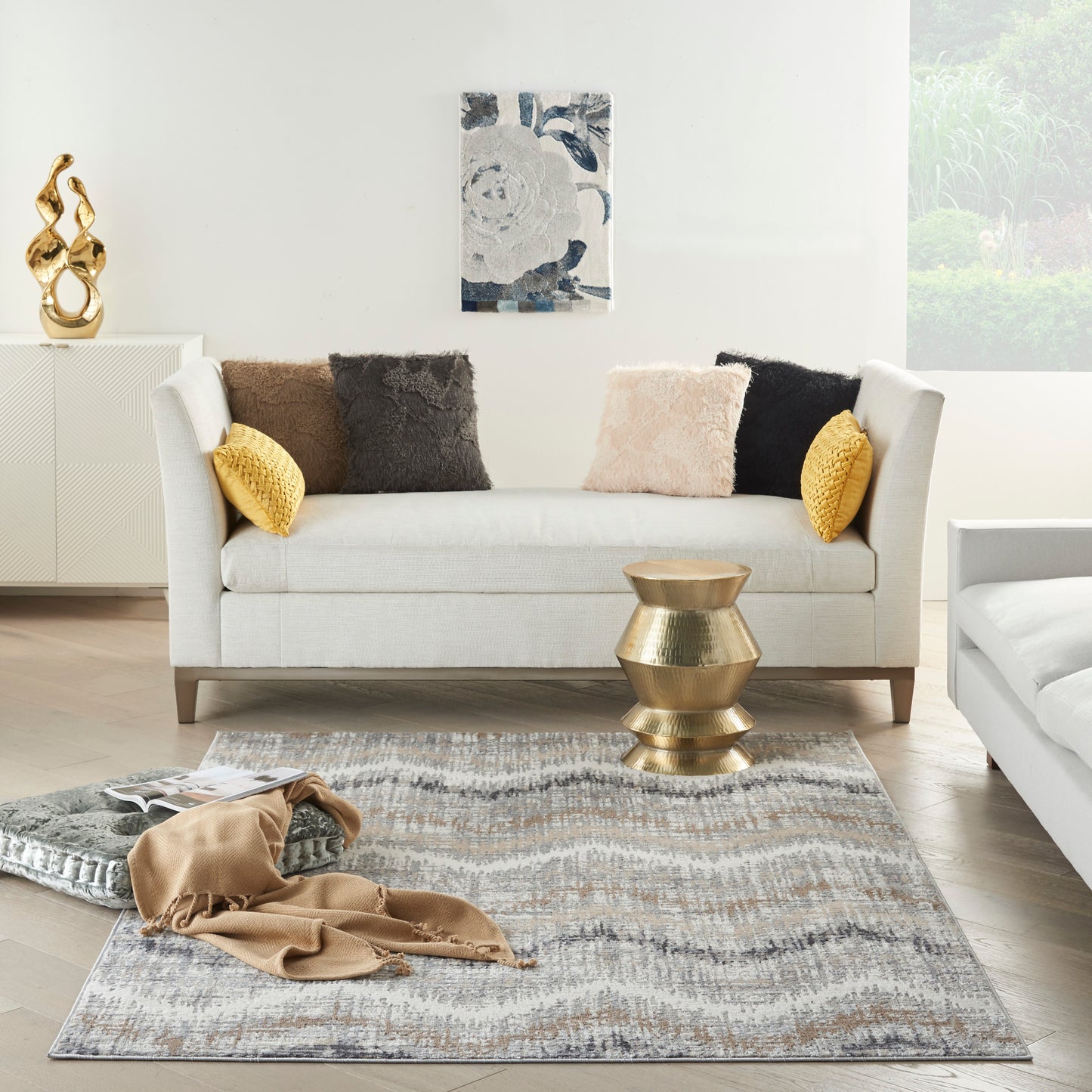 Abstract patterned rug in neutral tones in a sunlit contemporary living room.