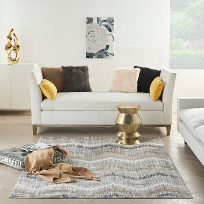 Abstract patterned rug in neutral tones in a sunlit contemporary living room.