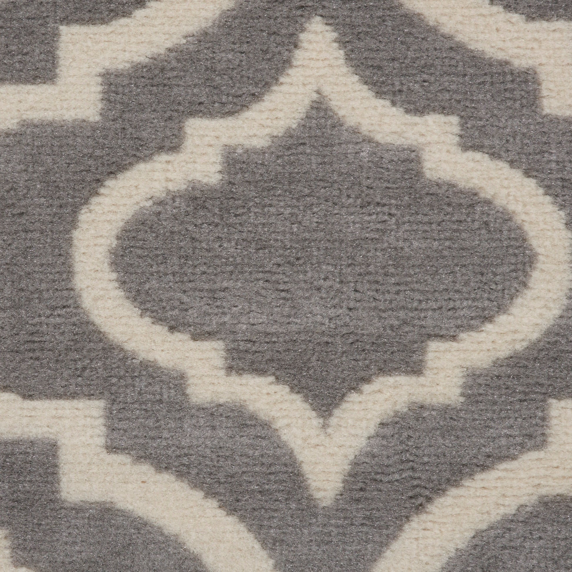 Gray rug with cream Moroccan trellis pattern featuring symmetrical quatrefoil shapes.