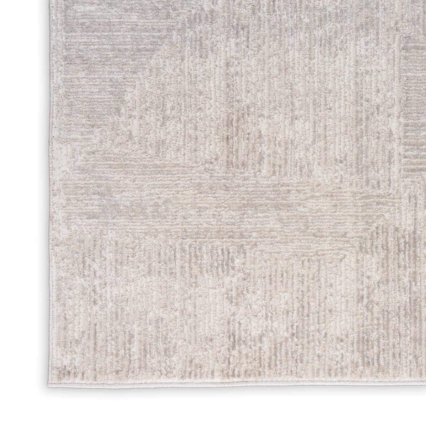 Neutral beige area rug with subtle geometric patchwork pattern and soft texture.