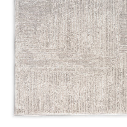 Neutral beige area rug with subtle geometric patchwork pattern and soft texture.