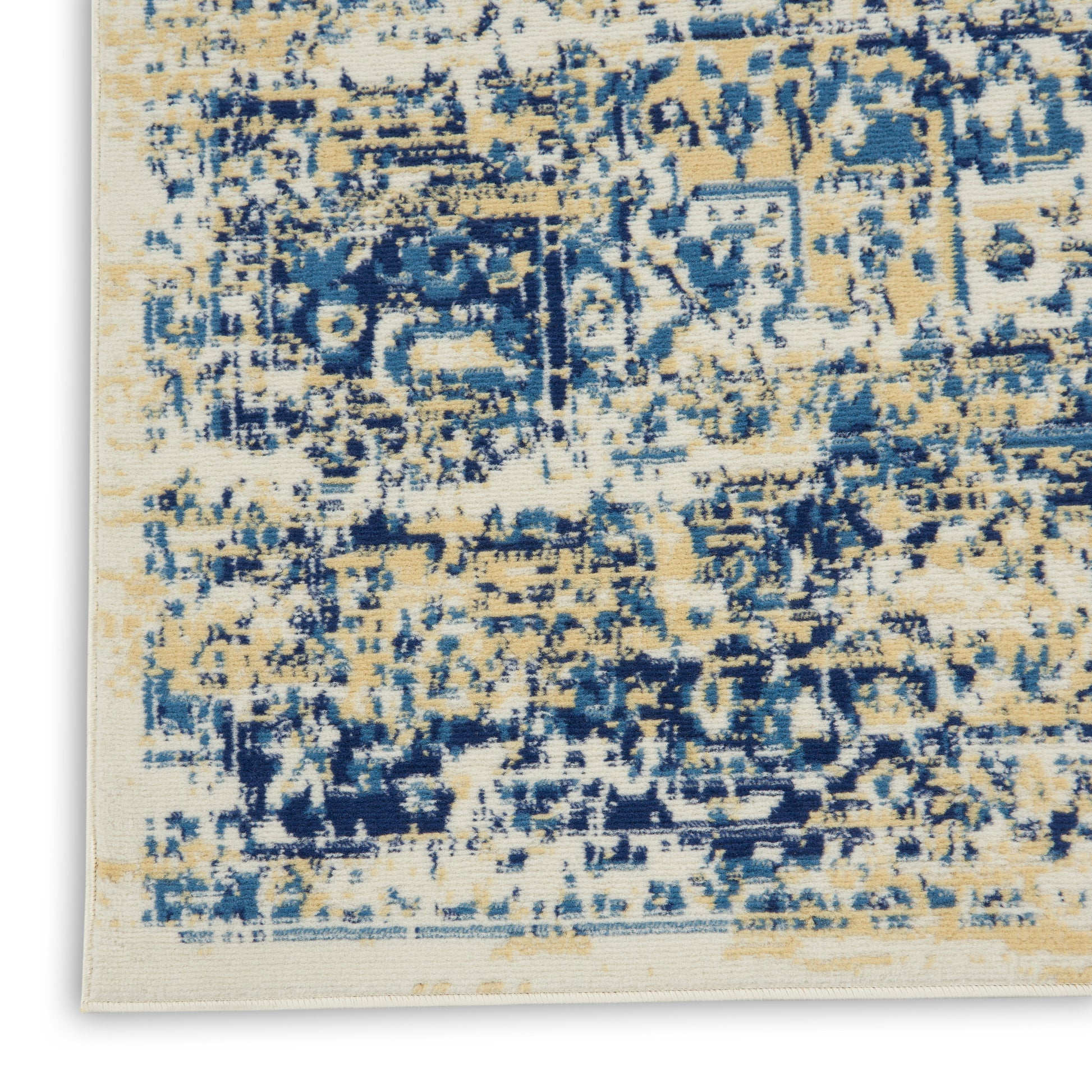 Close-up of a distressed abstract area rug in cream, navy blue and tan with a textured pile.