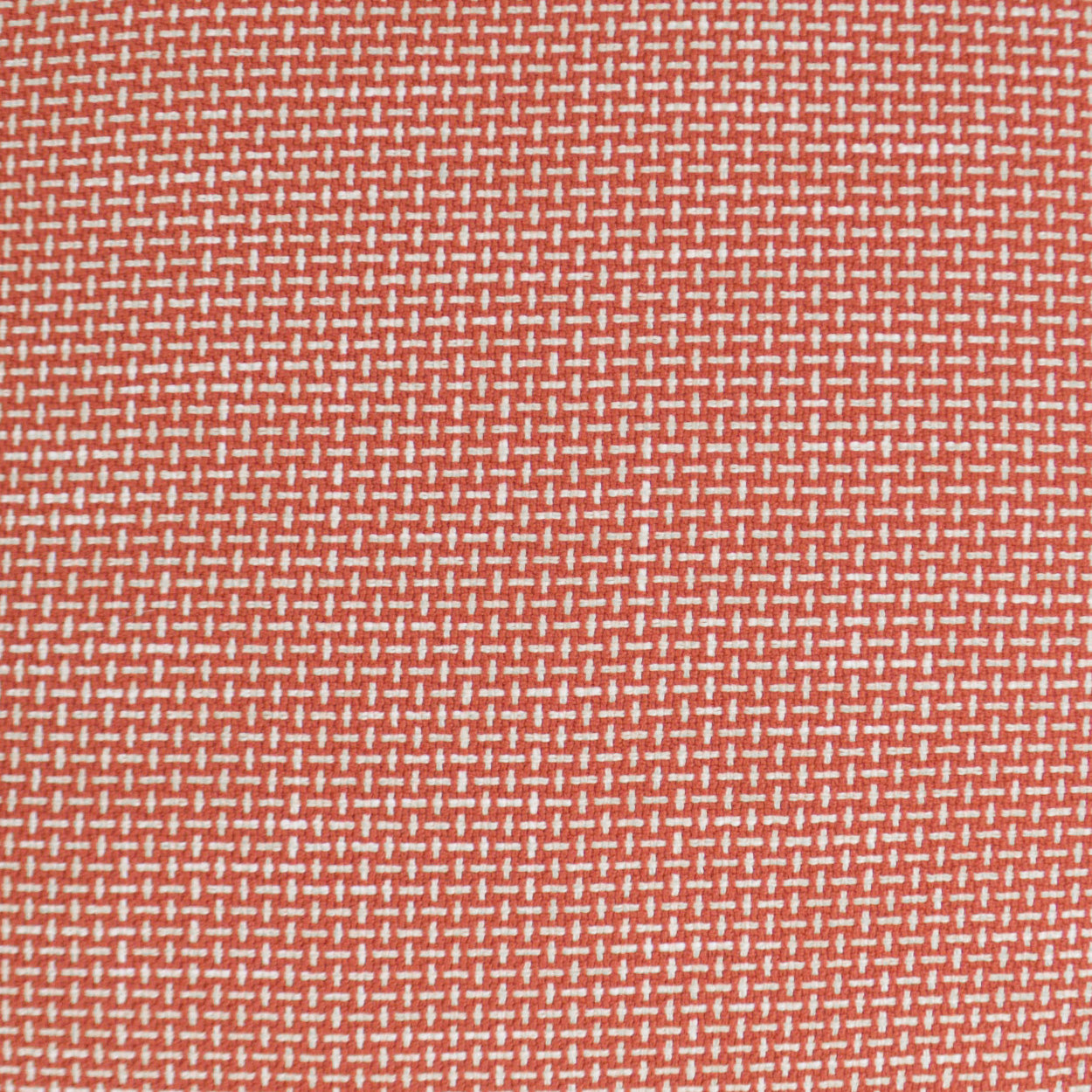 Rust-orange woven fabric with tiny white dash pattern; versatile upholstery textile.