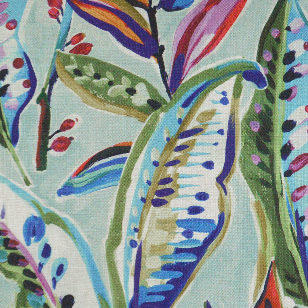 Vibrant tropical leaf print fabric in blues, greens and purples on a pale aqua background; bold painterly textile.