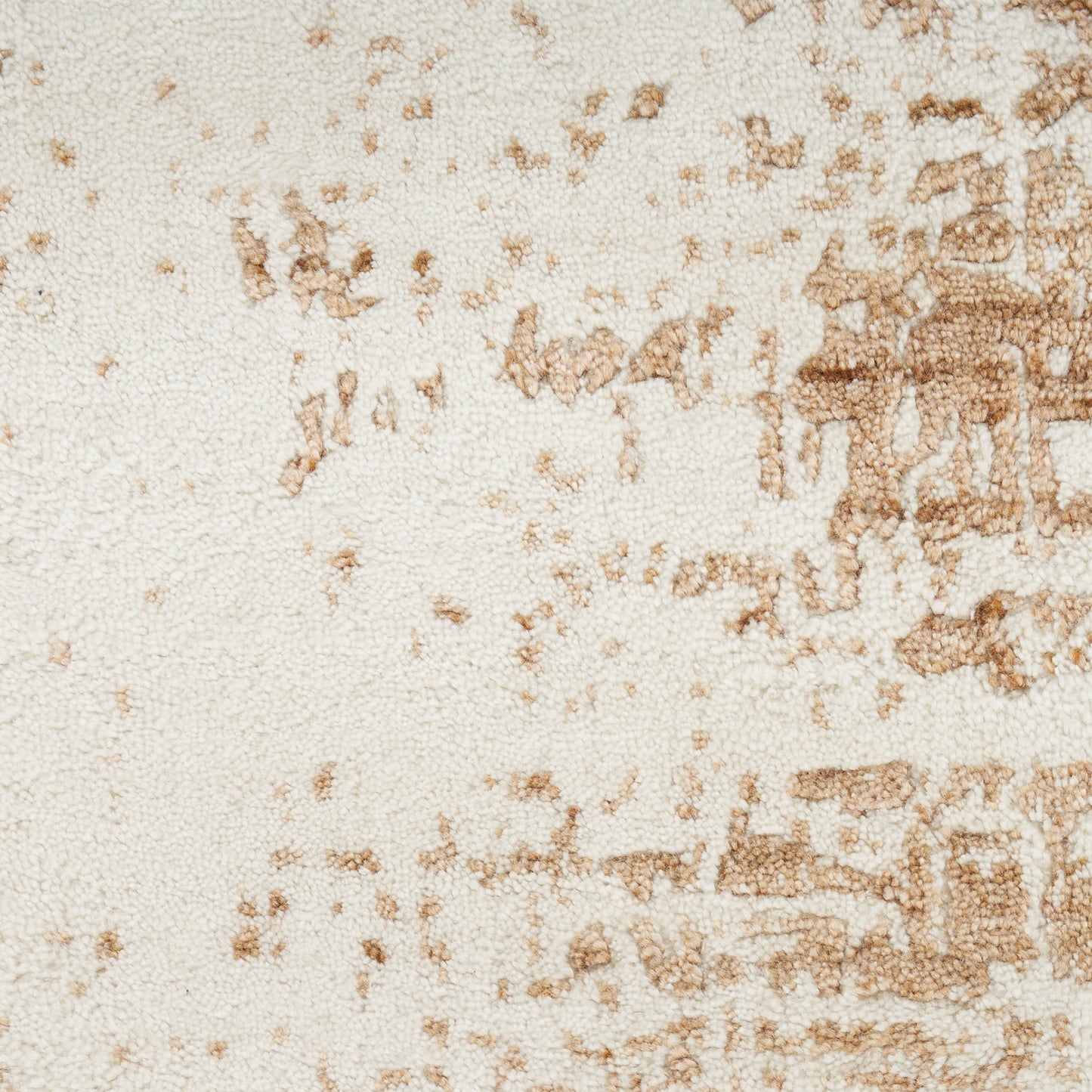 Cream textured rug with tan abstract motif; rectangular, woven wool blend for cozy living room decor.