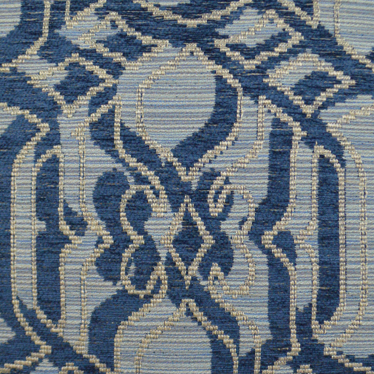 Blue and ivory woven fabric with damask-style geometric medallion pattern.