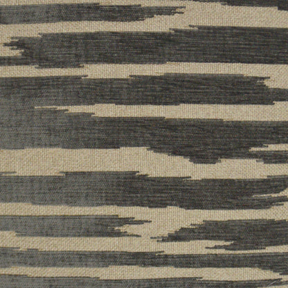Grey abstract pillow with beige woven fabric and irregular dark gray brushstroke bands.