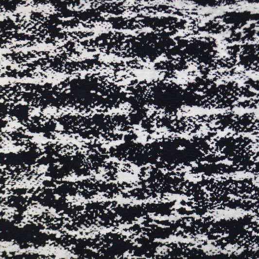 Black and white speckled fabric texture with a marled tweed-like pattern, ideal for upholstery or apparel.